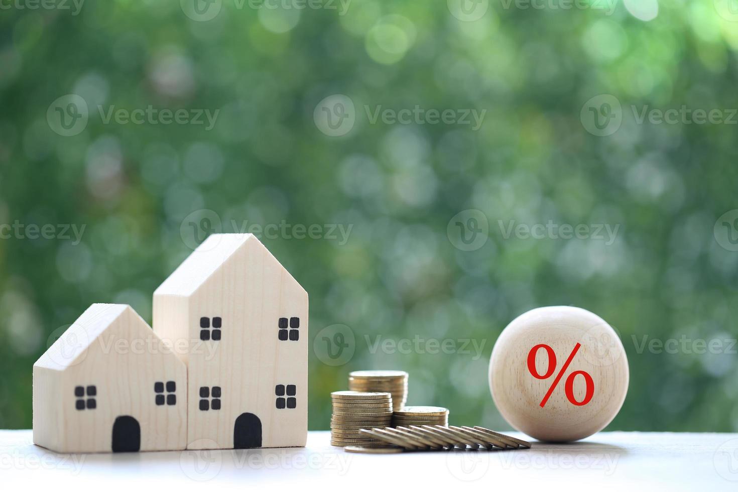 Interest rate up and Banking concept, Model house with Percentage symbol icon and stack of coins money on natural green background, Fixed Rate photo