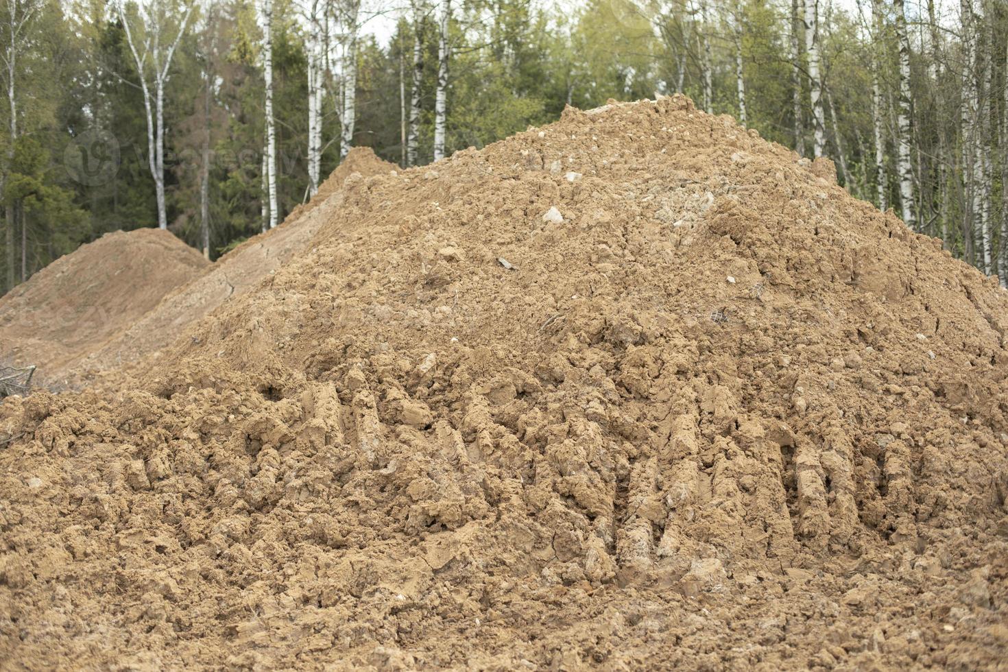 Sand on construction site. Building material is piled up in heap. photo