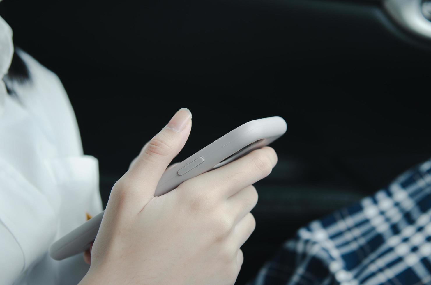 close up woman hand holding a mobile phone in the car cabin. photo