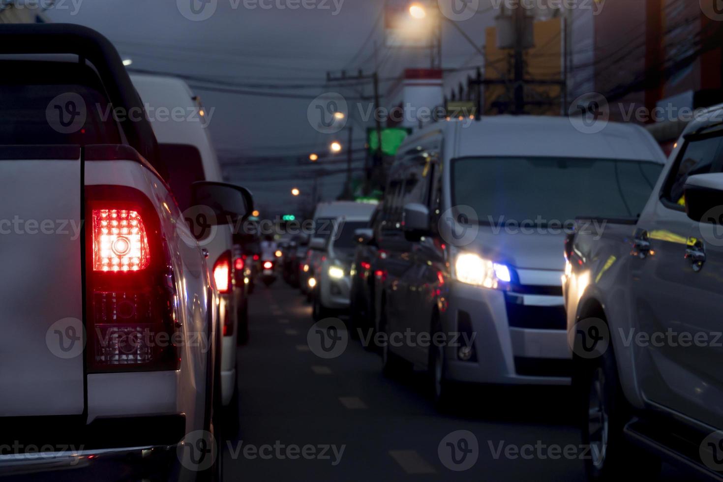 Abstract and blurred rear side of bickup car open light brake at night. Traffic jam in the city. Environment night time in the city. Light of the pole and headlights on the opposite side of the car. photo