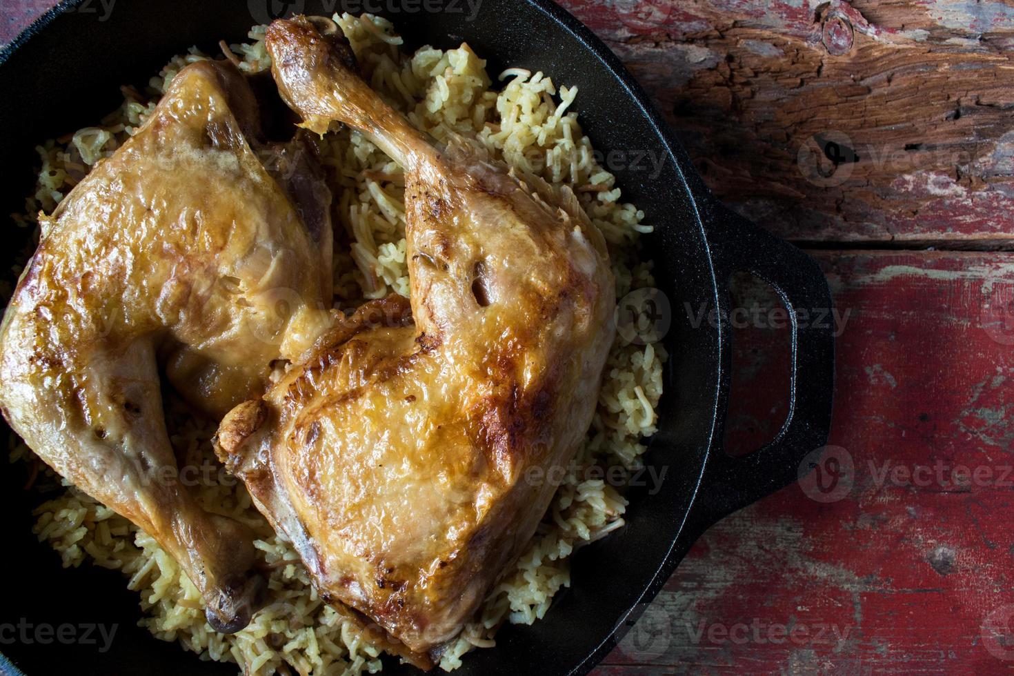 baked chicken on top of wild rice on cast iron flat lay photo