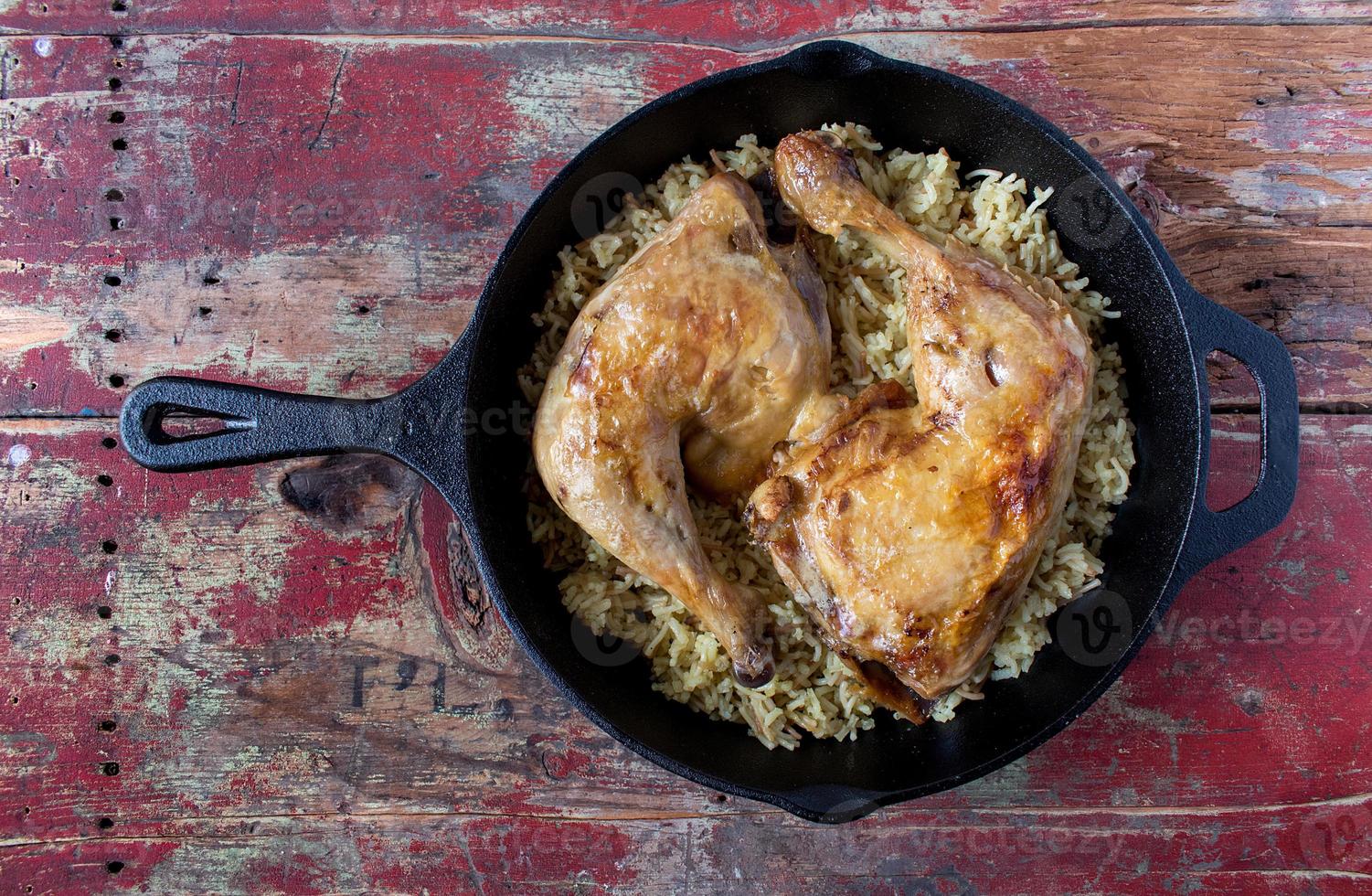 baked chicken on top of wild rice on cast iron flat lay photo