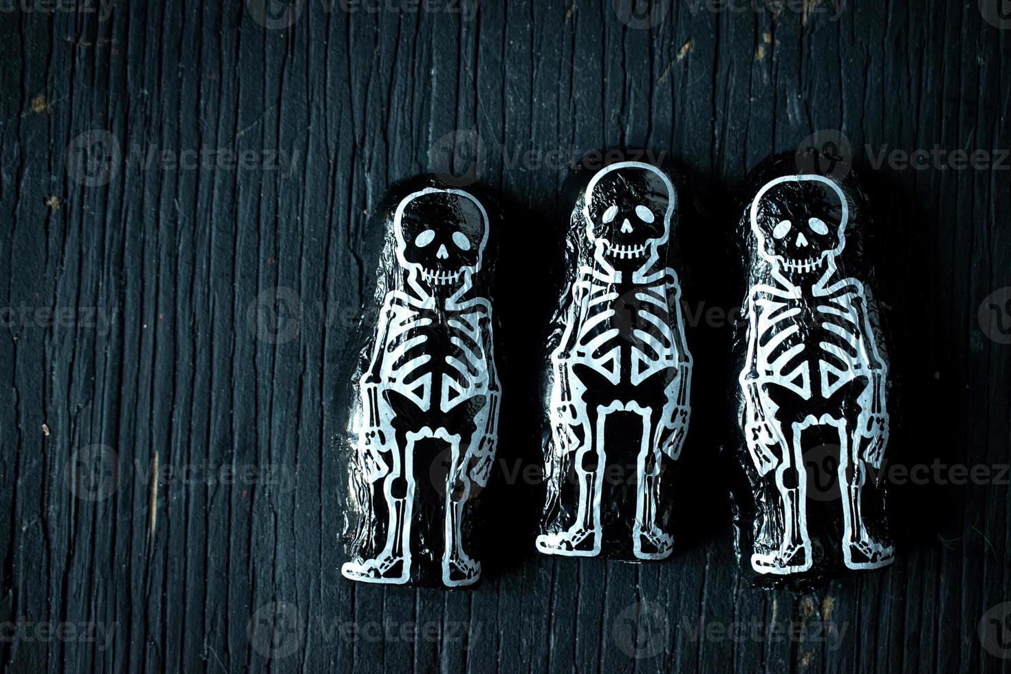 Halloween skeleton candy on dark wood photo