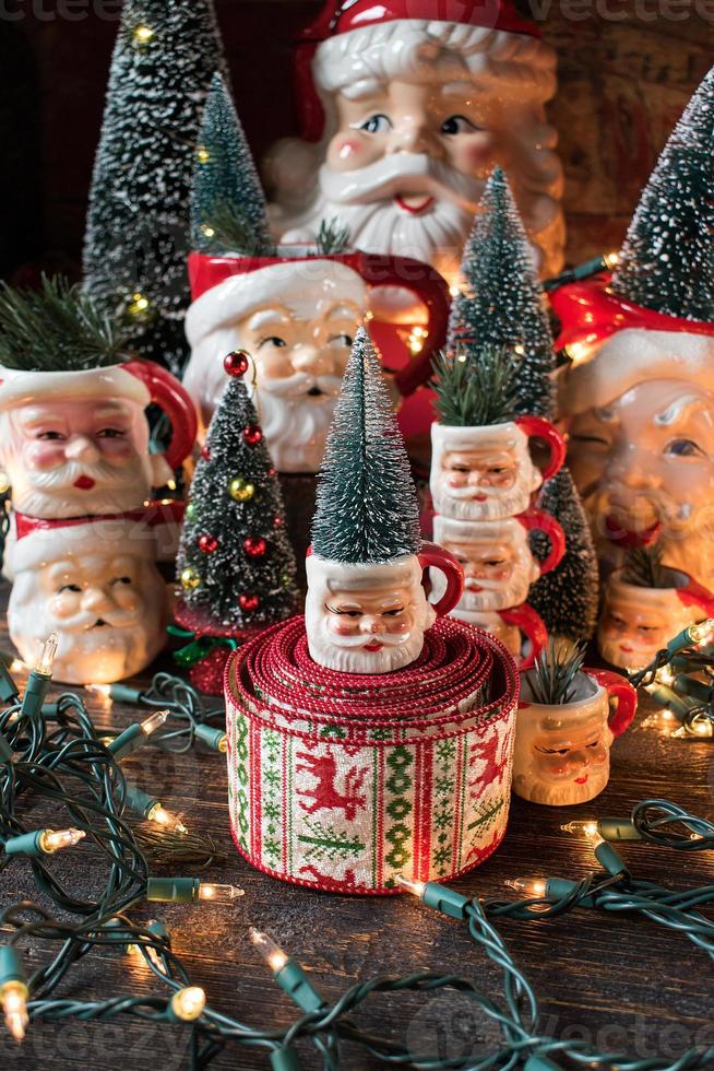 Collection of Christmas Santa mugs in holiday setting photo