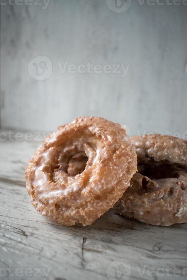 stack of glazed donuts on rustic table photo