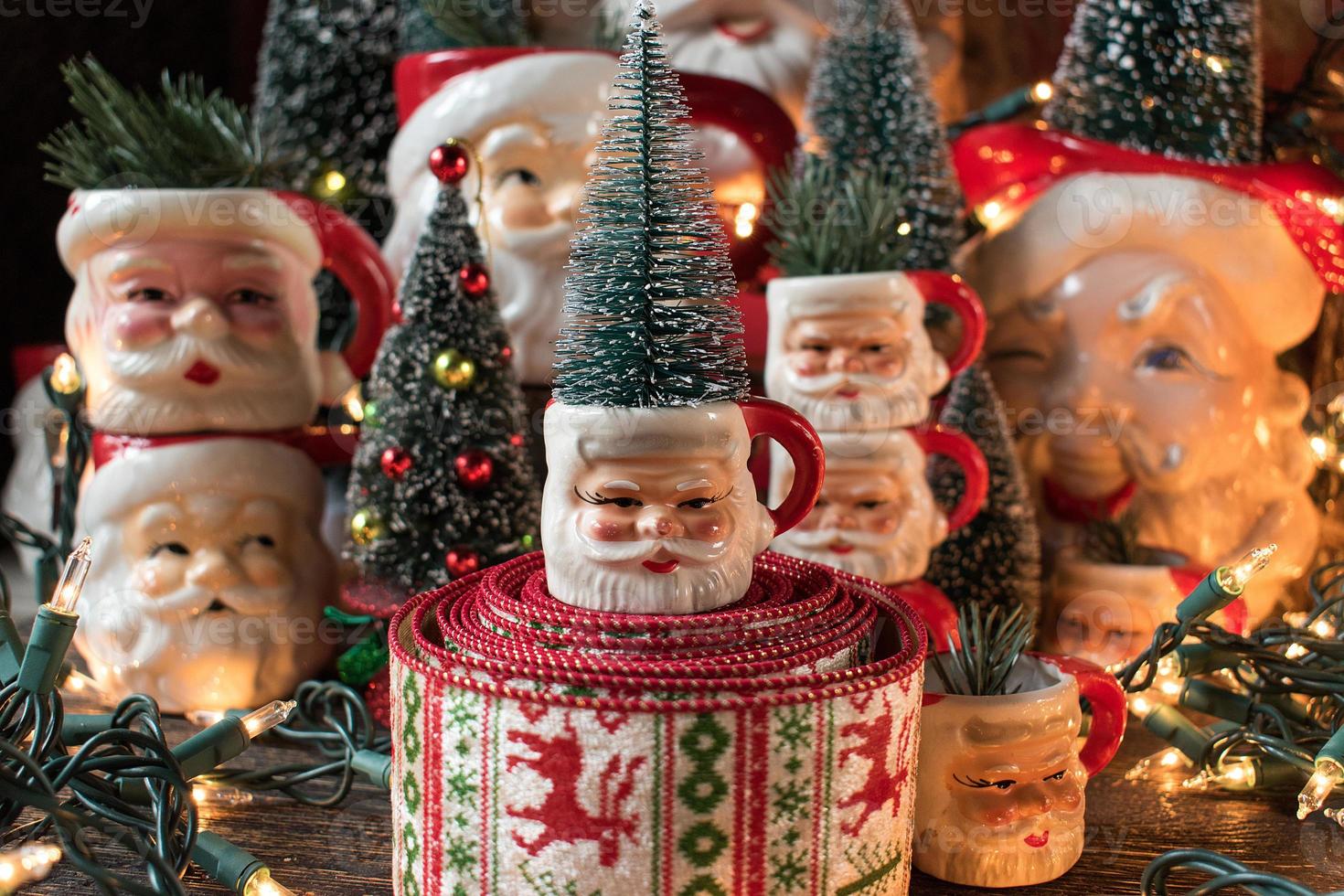 Collection of Christmas Santa mugs in holiday setting photo