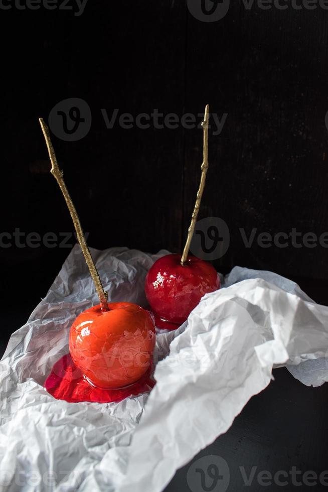 Halloween candy apple with gold stick on dark background photo