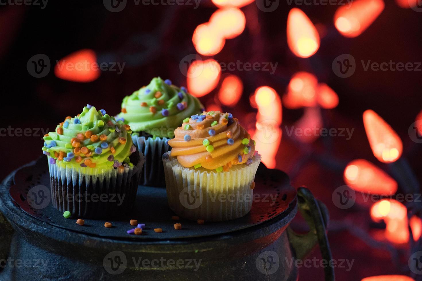 Halloween cupcakes with sprinkles in spooky lights setting photo