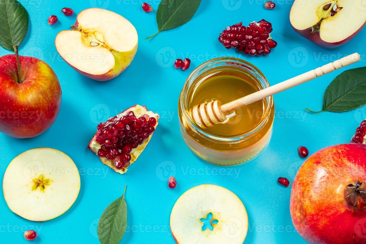 Happy Rosh Hashanah. Pattern from apples, honey and pomegranates on blue background. Jewish traditional religious holiday. photo