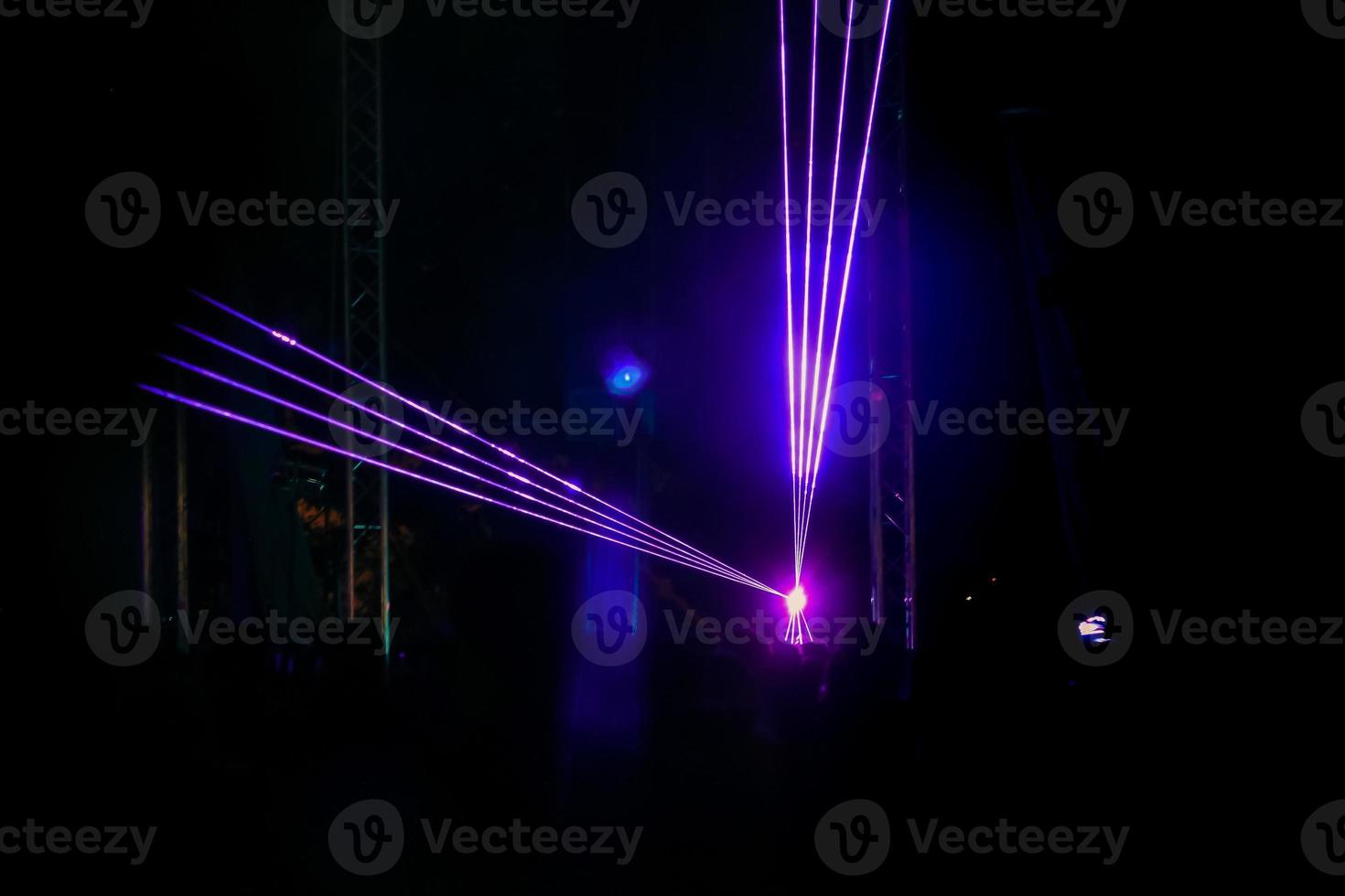 Purple laser neon beams. Crowd of people watching laser show at street festival. photo