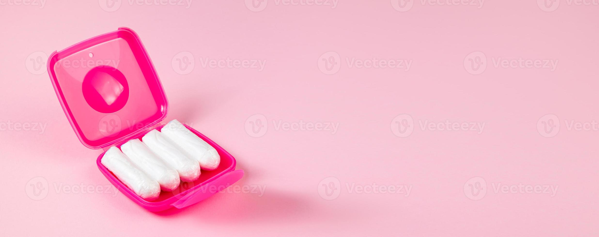 Tampons in pink box. Feminine hygiene products on pastel background. photo