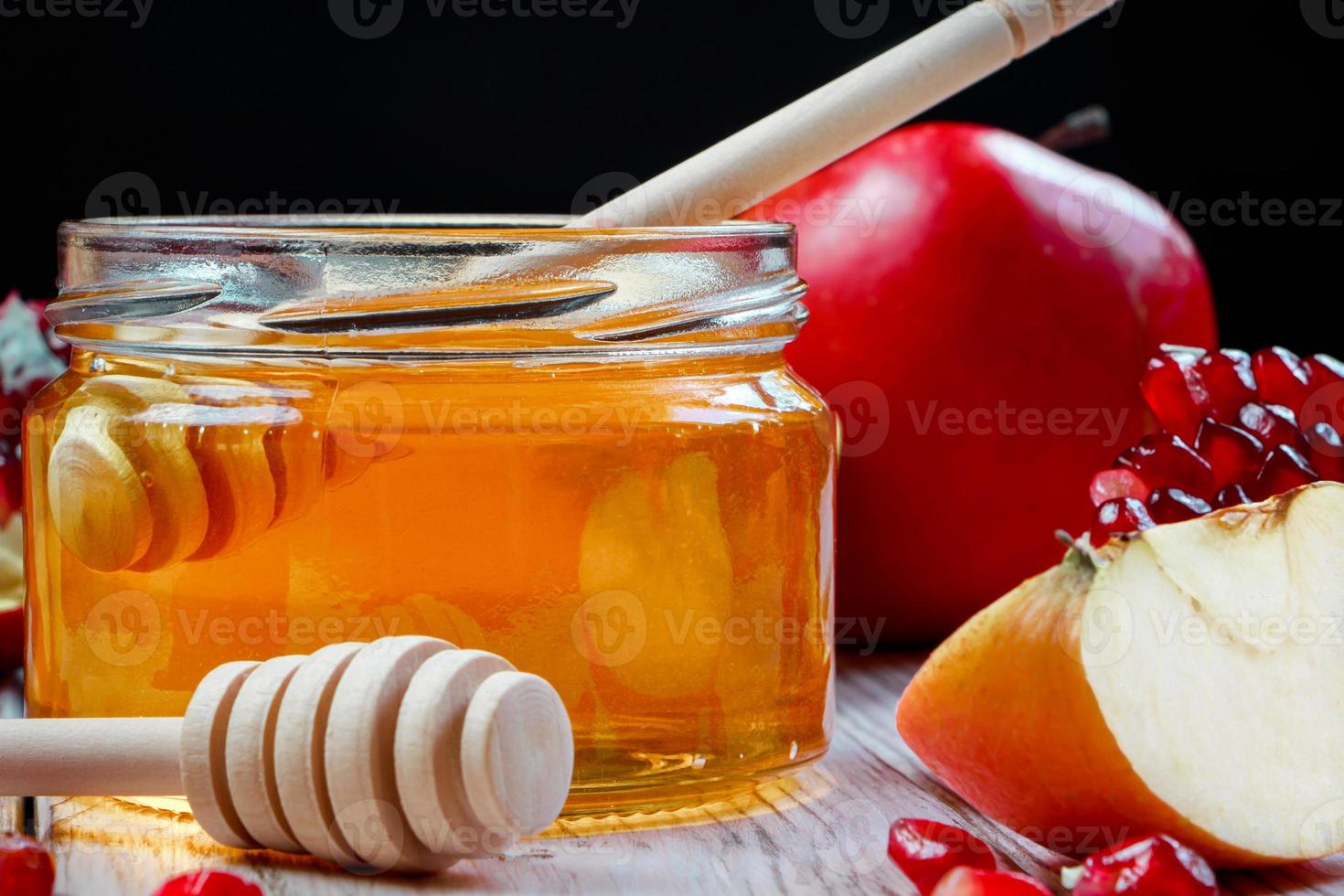 Traditional Jewish religious holiday Rosh Hashanah. Apples, pomegranates and honey on dark wooden background. photo