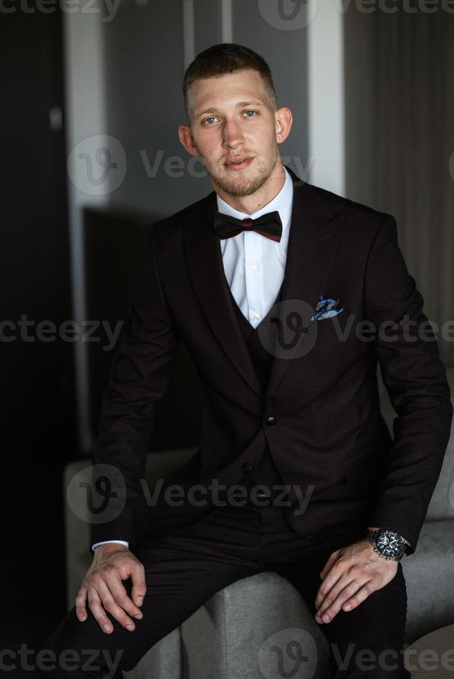portrait of the groom in a brown three-piece suit photo