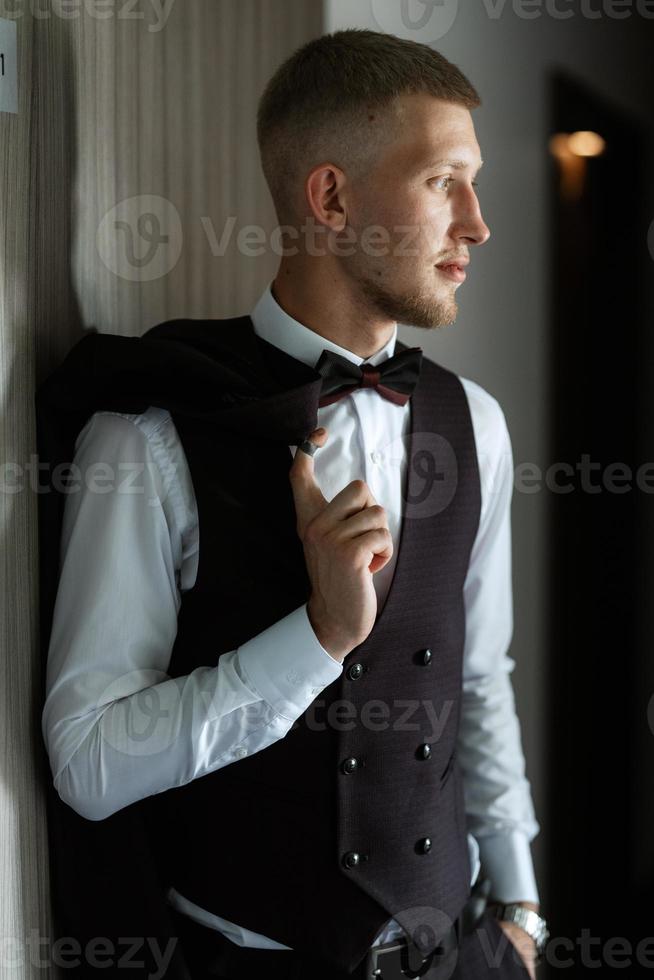 portrait of the groom in a brown three-piece suit photo