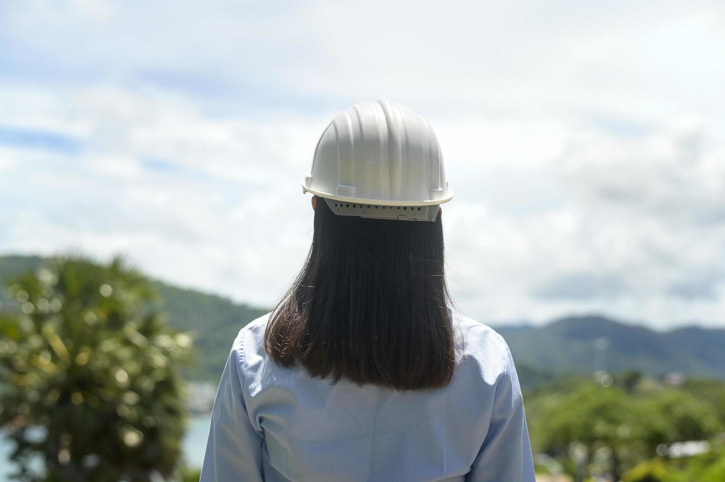 Female engineer working on the seaside wearing a protective helmet photo