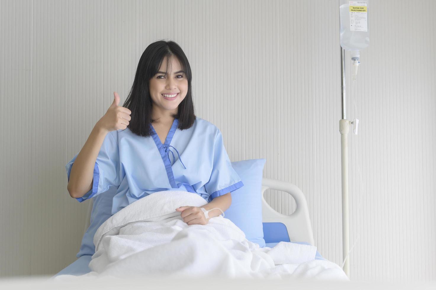 paciente joven esperanzada y feliz en el hospital, la atención médica y el concepto médico foto