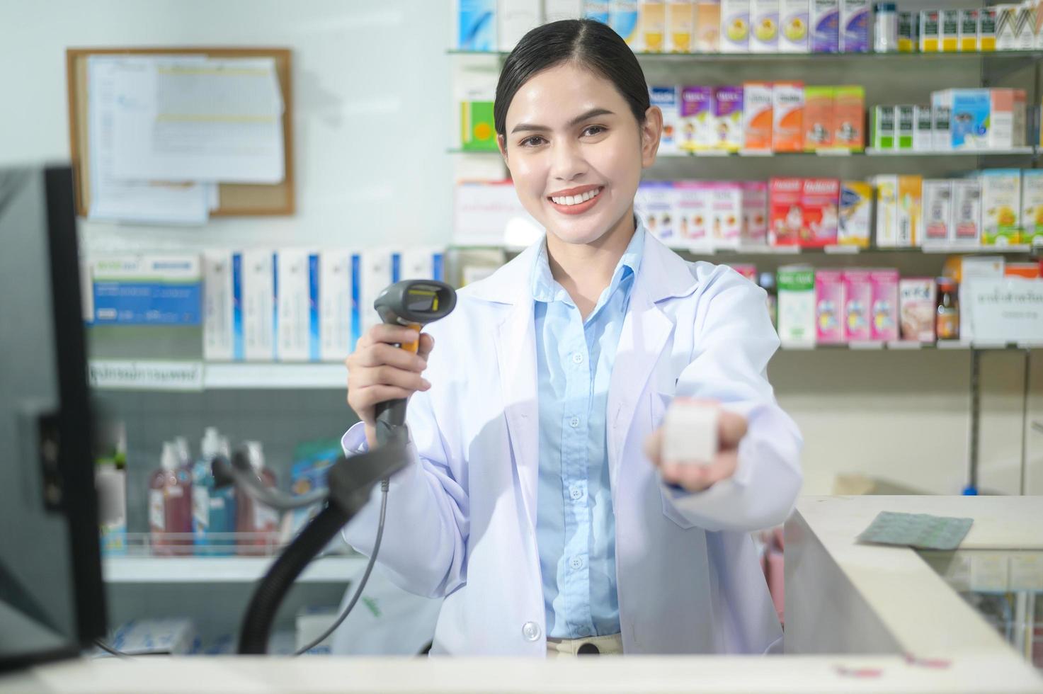 Farmacéutica femenina escaneando código de barras en una caja de medicamentos en una farmacia moderna. foto