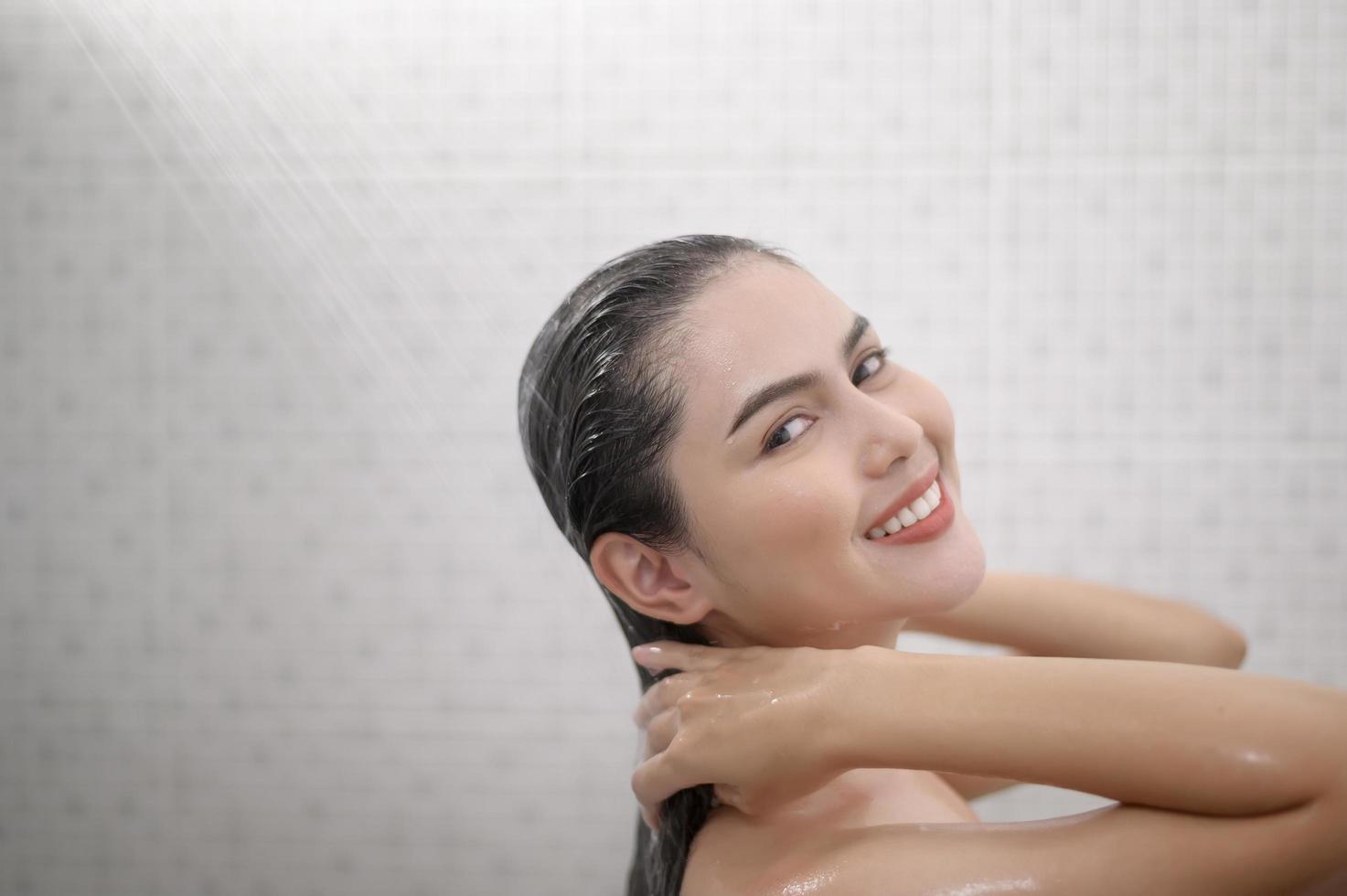 Happy beautiful woman is taking a shower photo