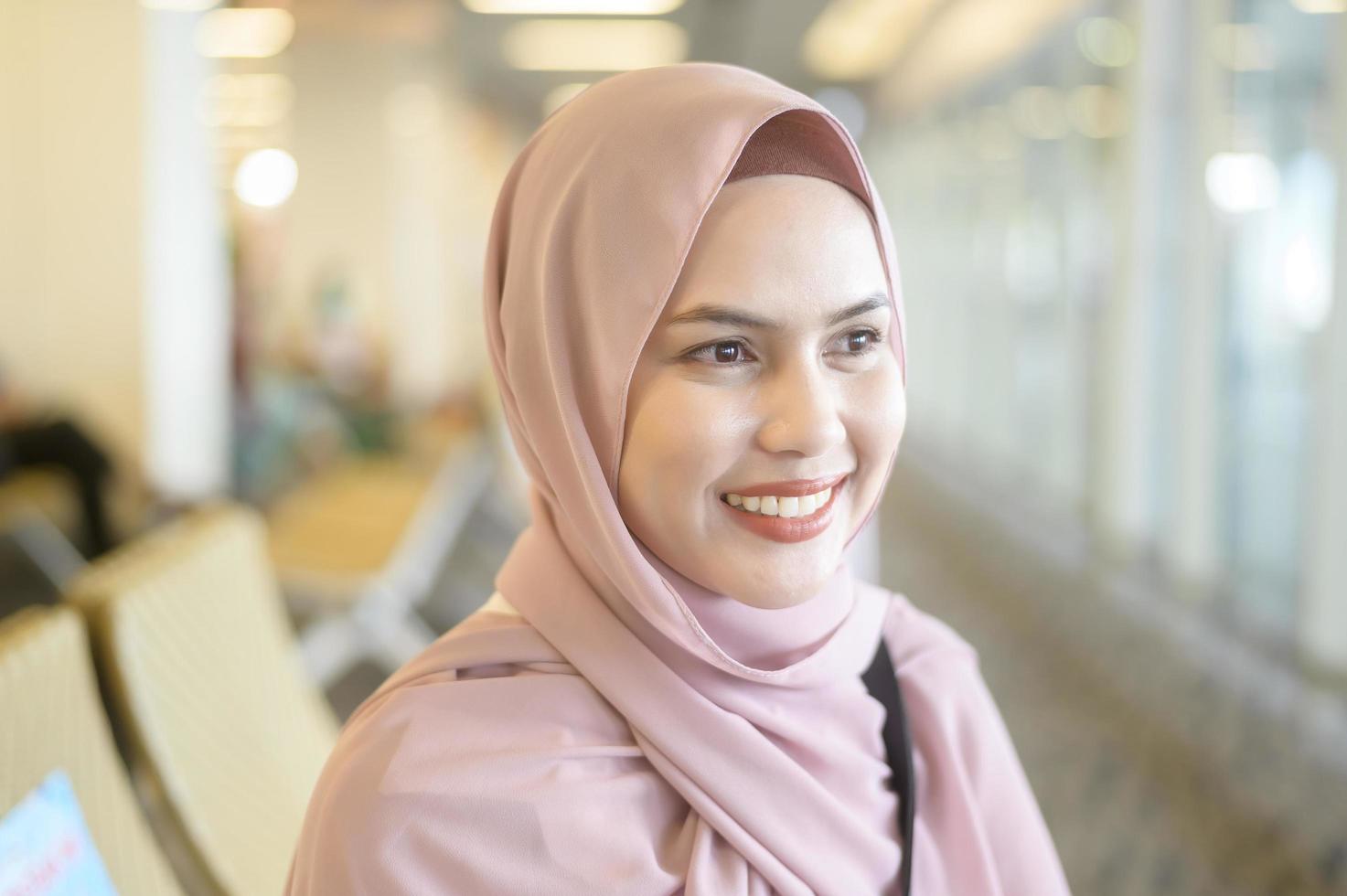 Young female muslim traveler carrying suitcases at the International airport, travel, holidays and journey concept. photo