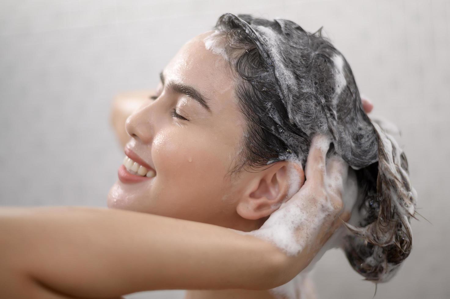 Happy beautiful woman is taking a shower photo