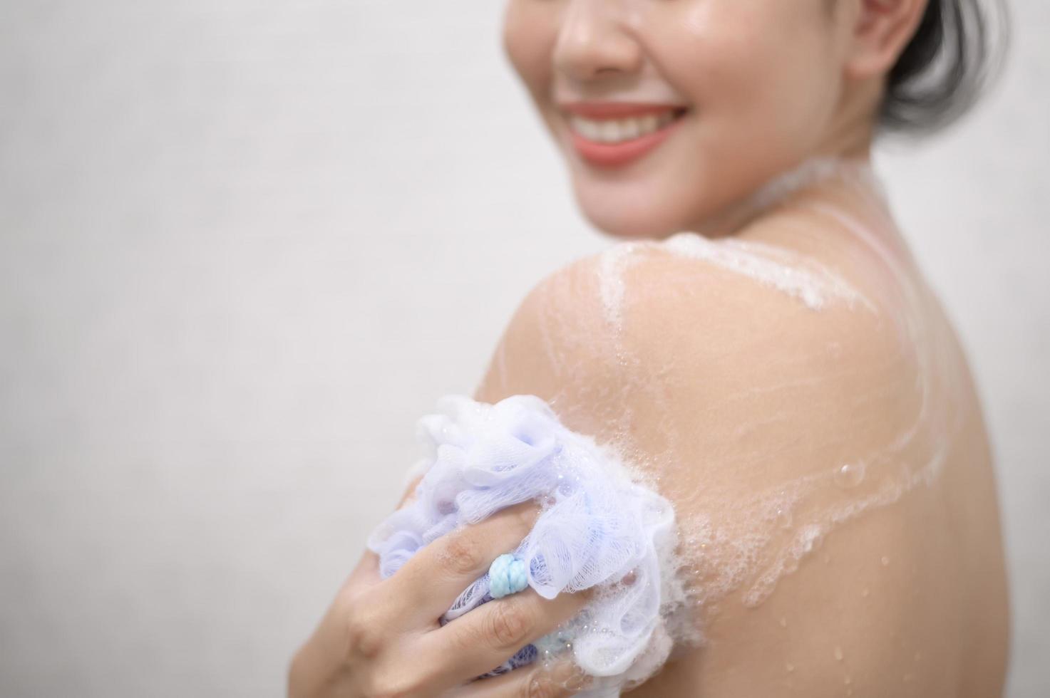 Happy beautiful woman is taking a shower photo