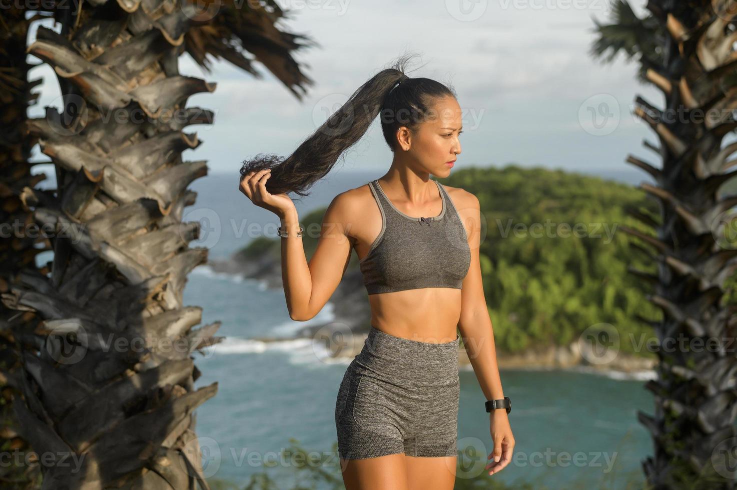 retrato de mujer hermosa en forma en ropa deportiva en el pico de la montaña junto al mar, concepto de salud y viaje. foto