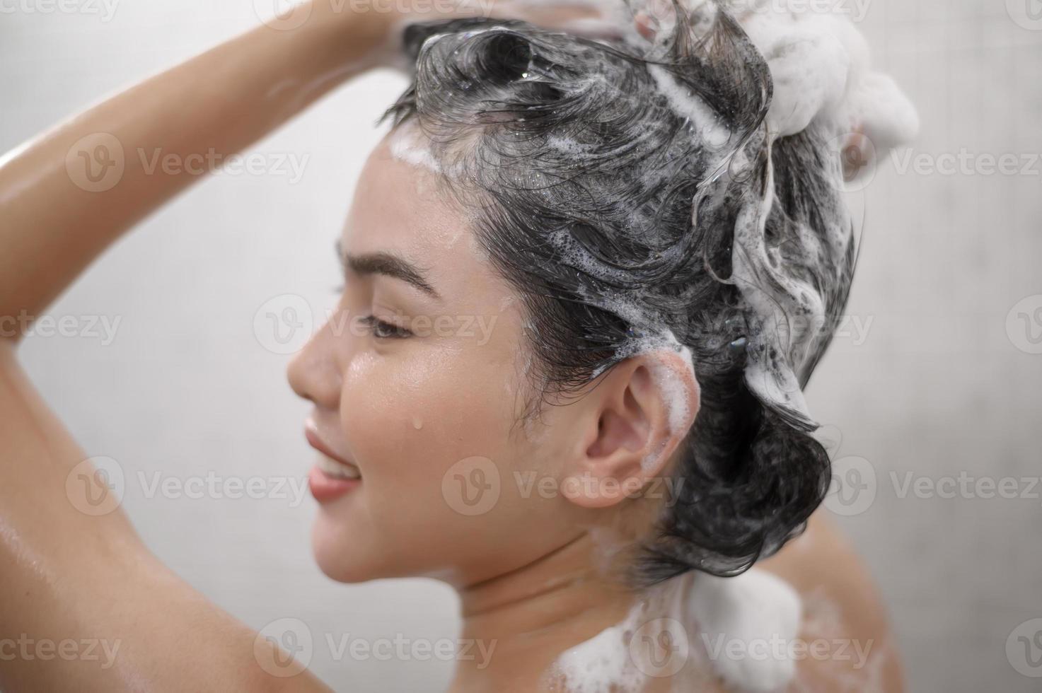 Happy beautiful woman is taking a shower photo
