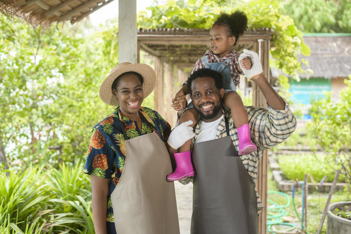 feliz familia de agrónomos negros disfrutando y trabajando en tierras de cultivo, concepto de agricultura foto