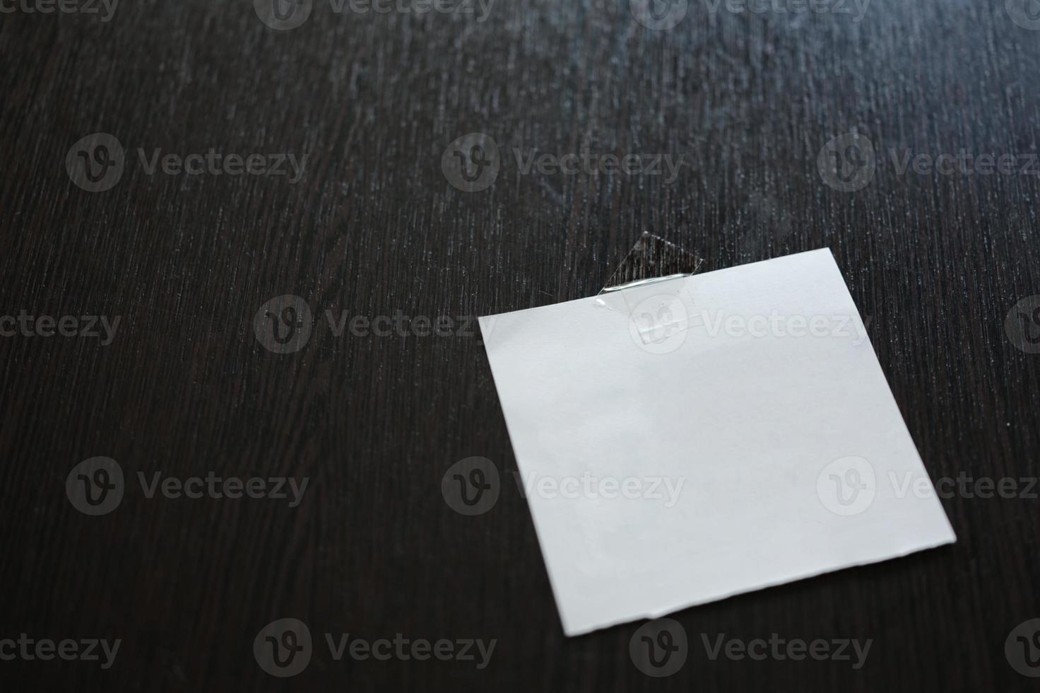 White paper pad on black wooden table . space for text photo