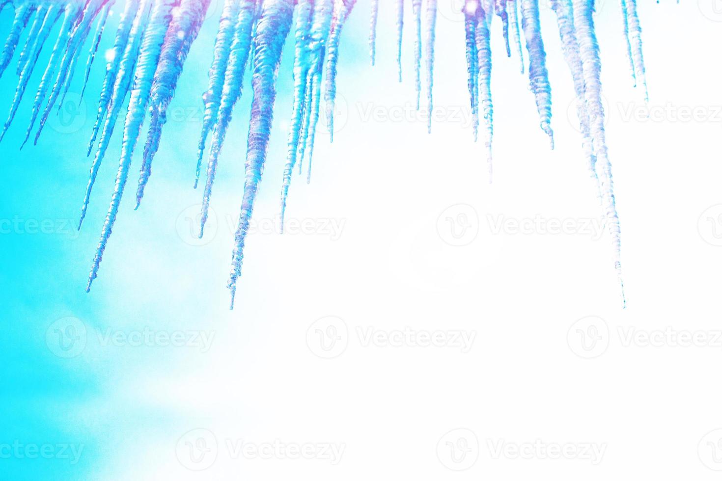 White icicles against the blue winter sky. photo