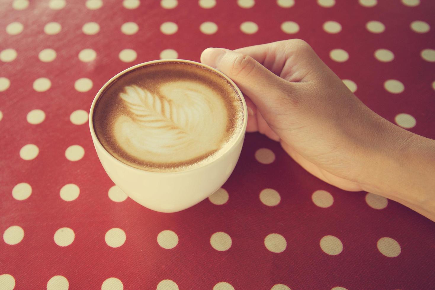 manos de mujer sosteniendo arte latte con color vintage foto