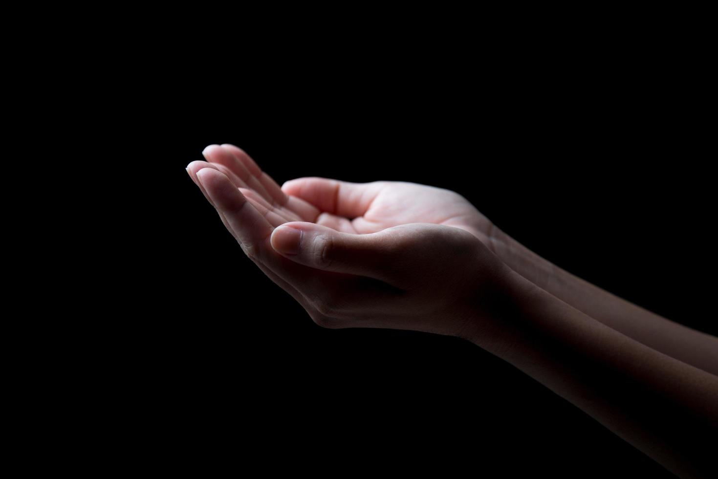 woman hands palms up over black background photo