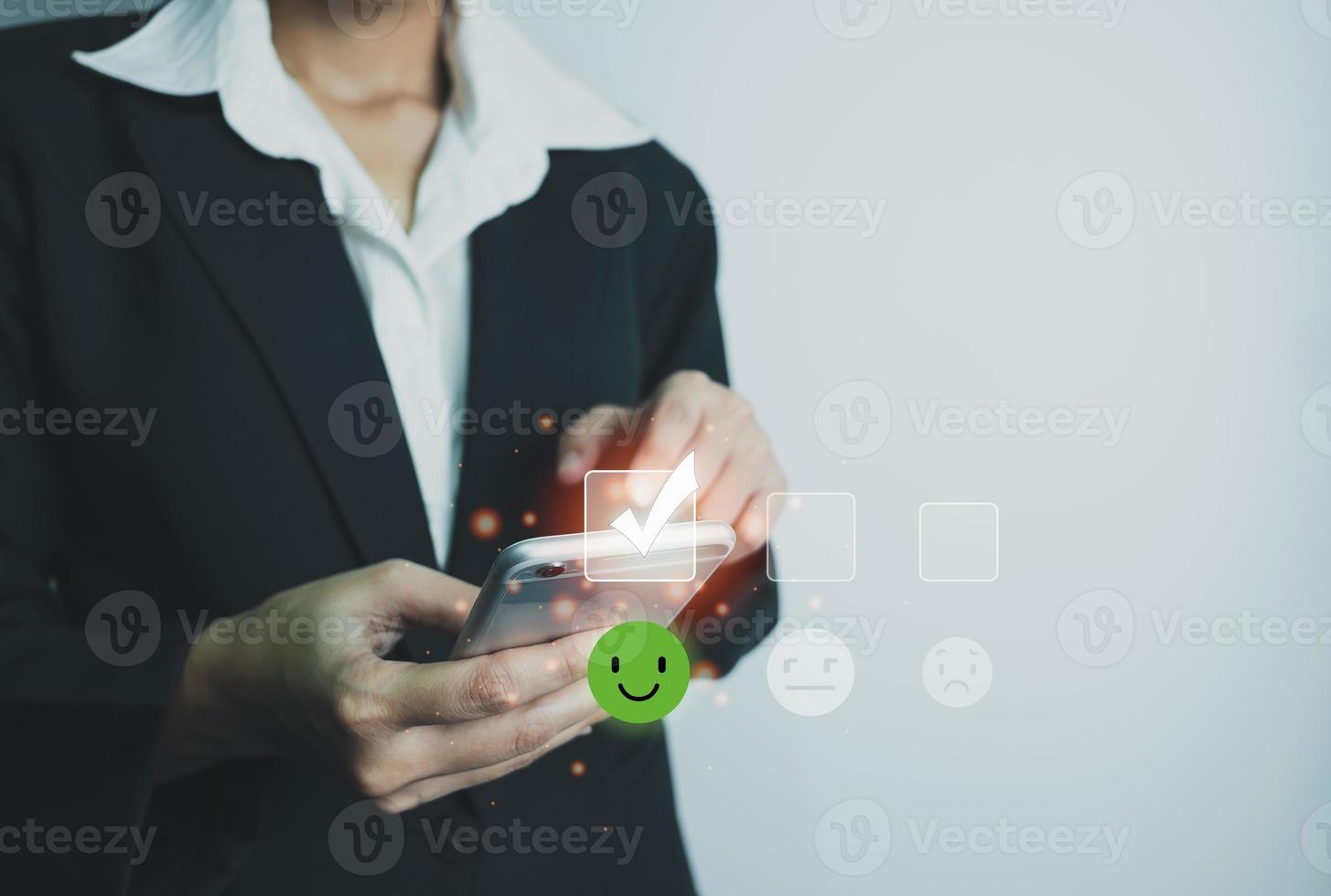 Businesswoman assess service satisfaction smile icon by smartphone, Corporate care high standard, ISO, customer care, Excellent level, quality guaranteed in service of company. the highest service. photo