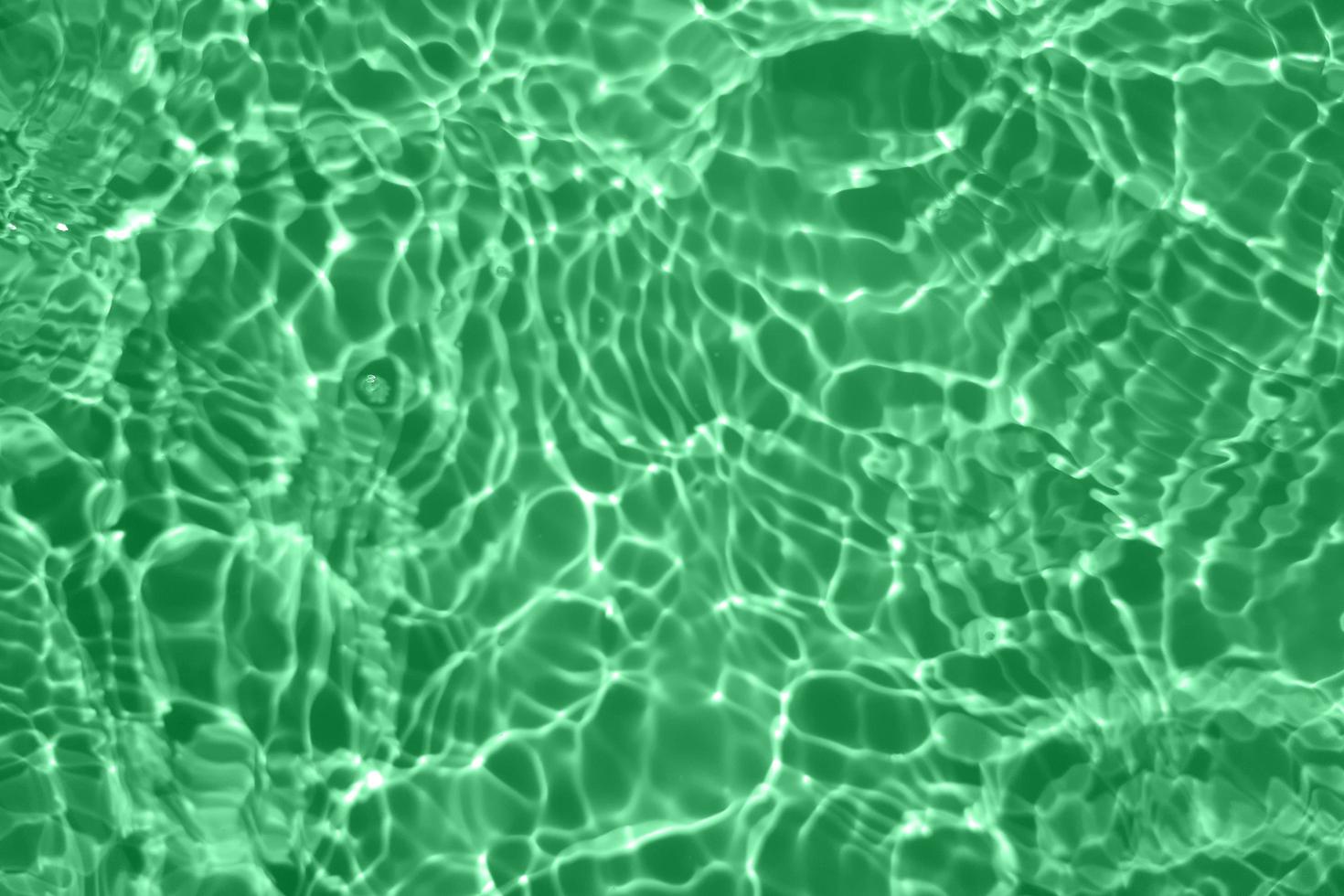 Defocus blurred blue water in swimming pool rippled water detail background. Water surface in the sea, ocean background. Water is an inorganic, transparent, tasteless, odorless, and nearly colorless. photo