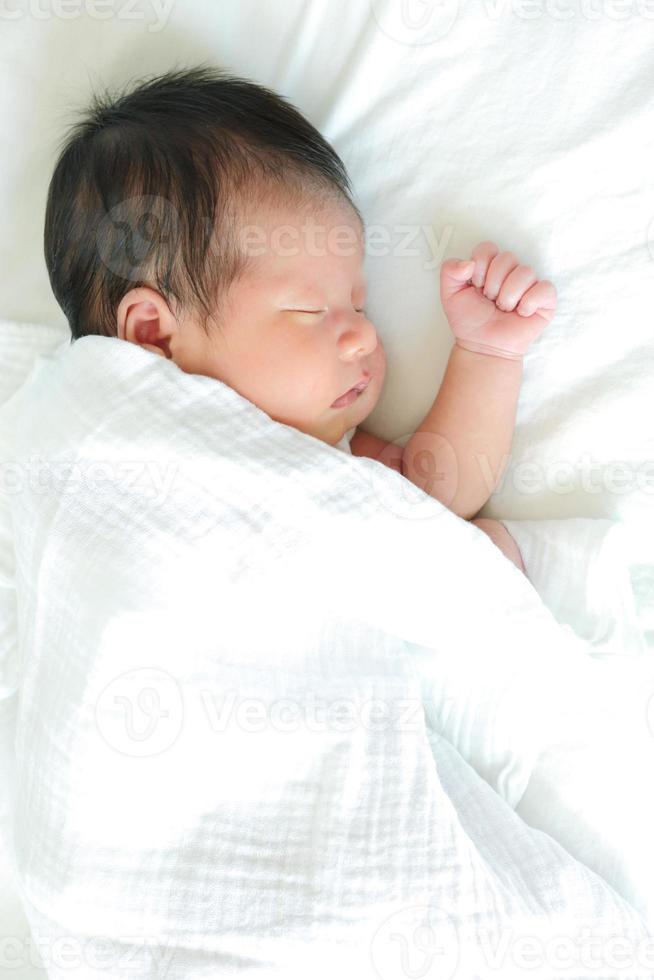 bebé asiático durmiendo en la cama, saludable con la madre para un nuevo concepto familiar foto