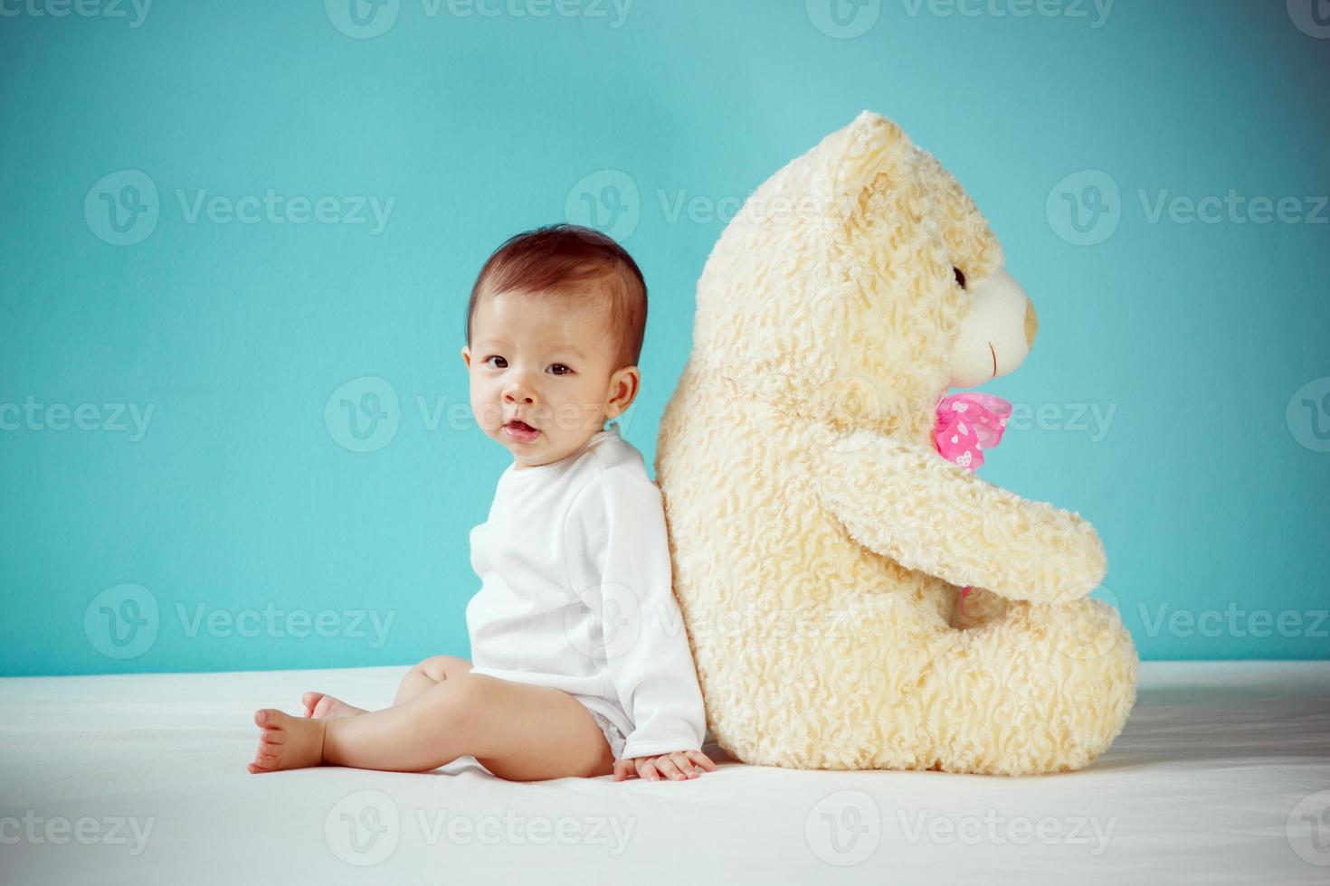 niña asiática jugando con su oso de peluche, niño sano con un nuevo concepto de familia foto