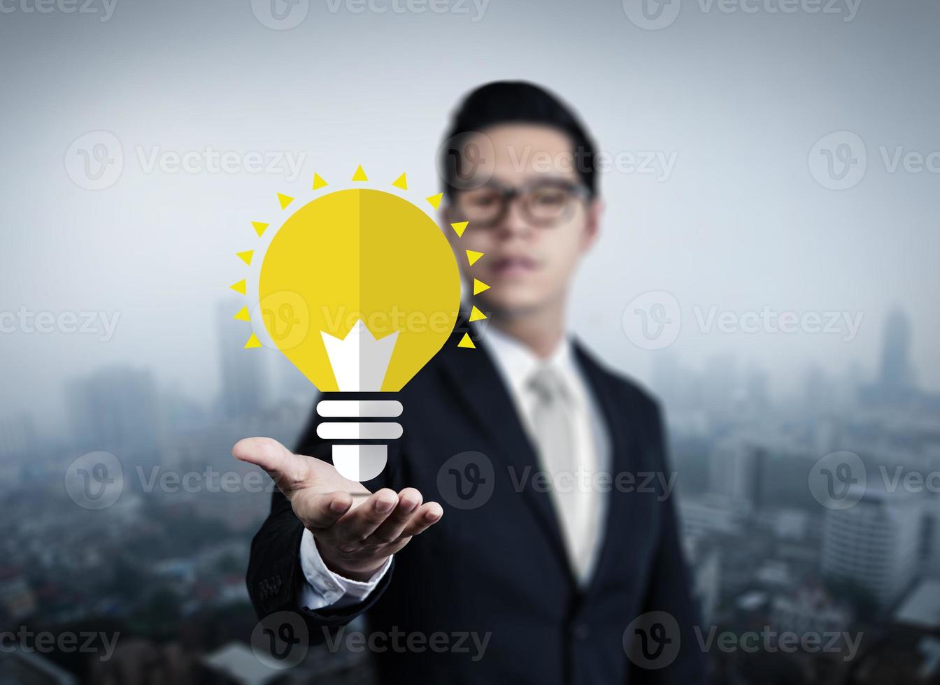 Concept idea of young businessman with bulb in hand, new business in the city collection, studio shot photo