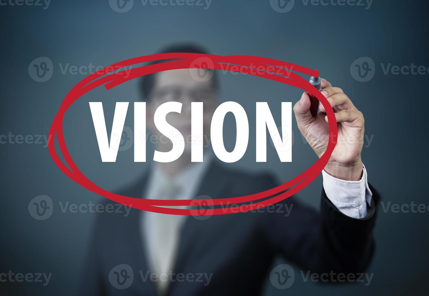 Businessman hand writing VISION with red marker on transparent board, new business concept, studio shot photo