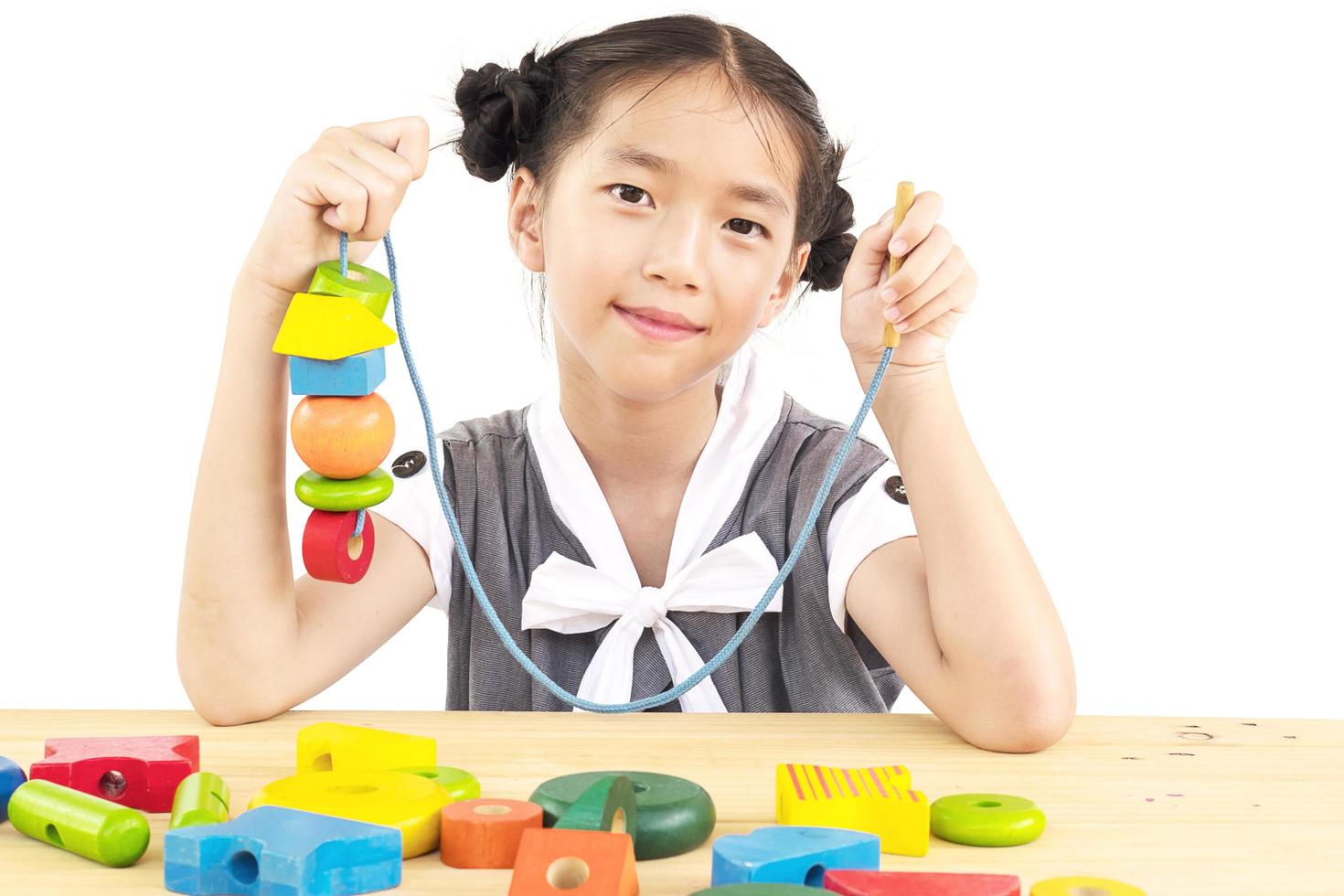 Lovely asian girl is play colorful wood block toy photo