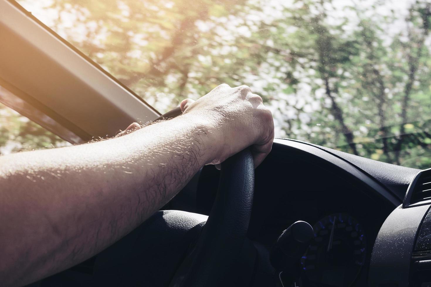 Man driving car using one hand photo