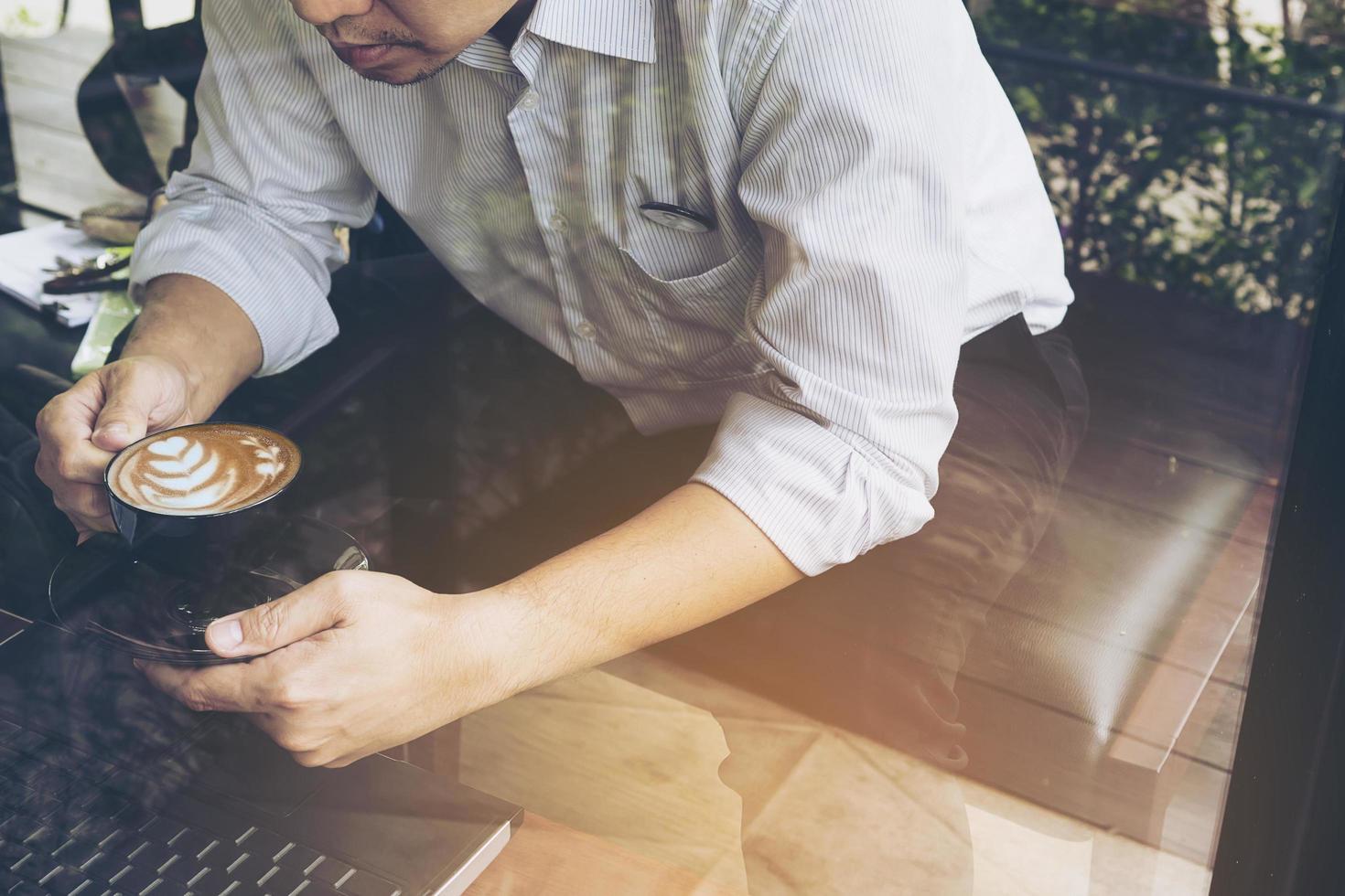 Businessman is working with his computer in coffee shop photo