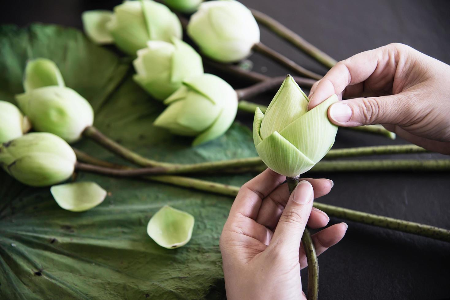 mujer preparando flores de loto para adorar la imagen de buda - dama y flores en concepto de religión foto