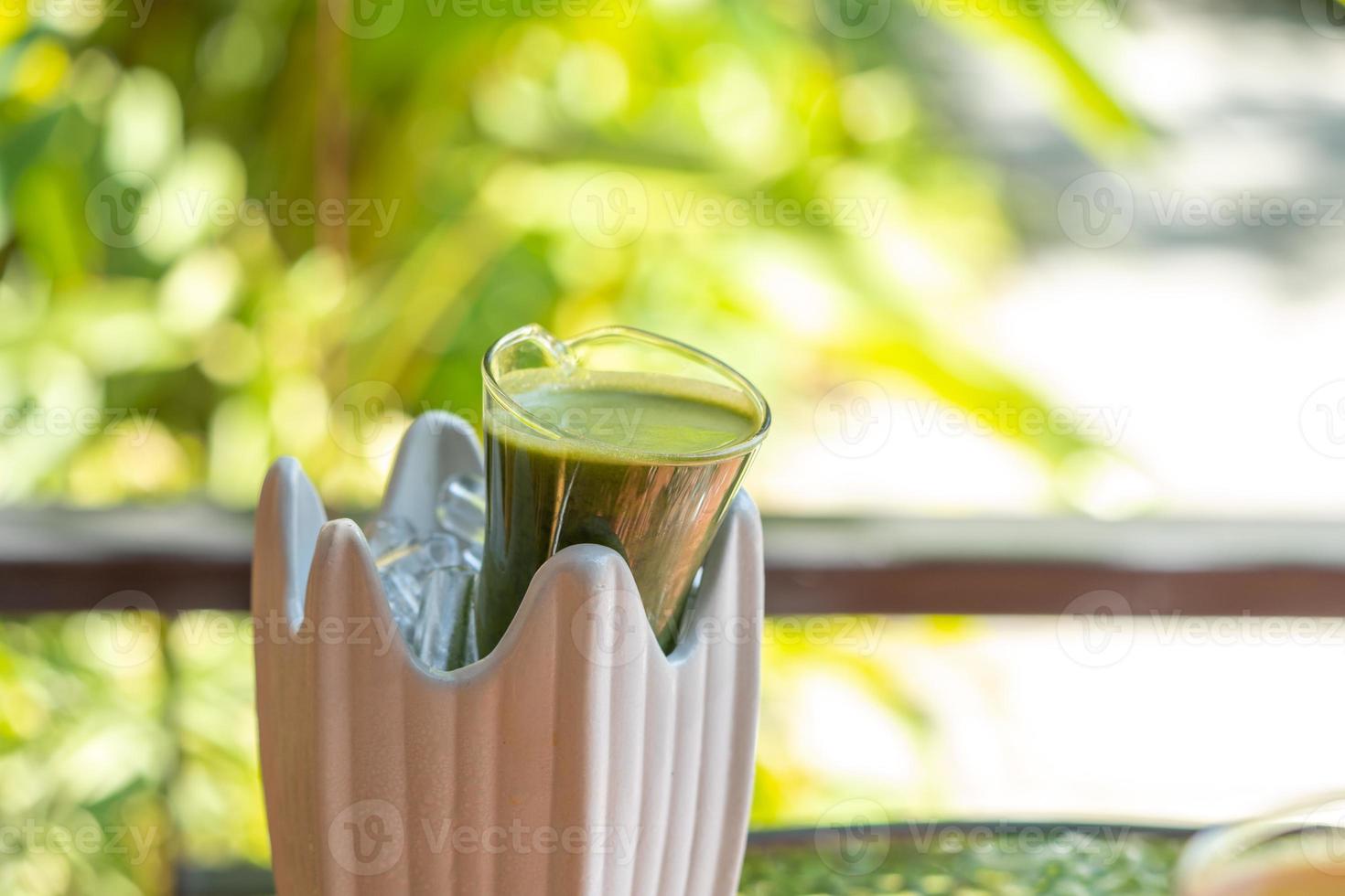 Green herb and fruit healthy drink are cooked and fill in glass jar then decorate with ceramic storage with ice inside. photo