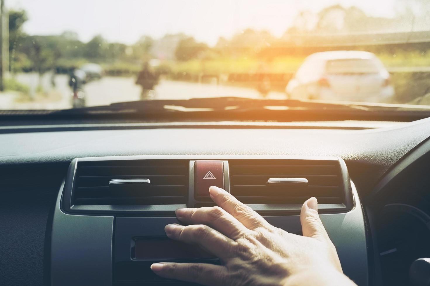 Man pushing emergency light button while driving car photo