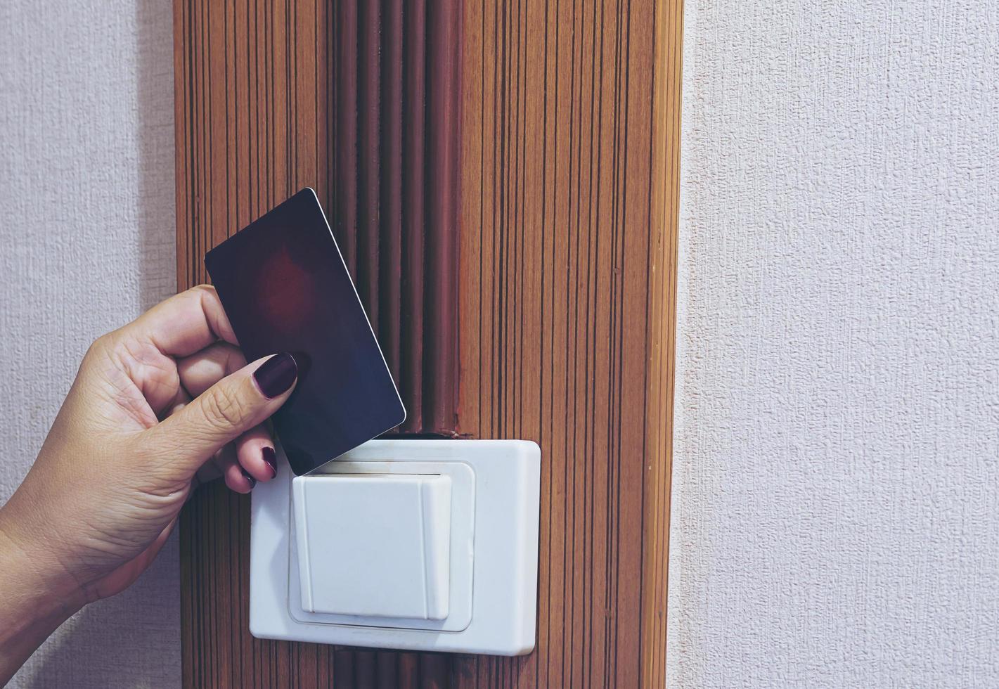Lady putting key card switch in hotel room photo