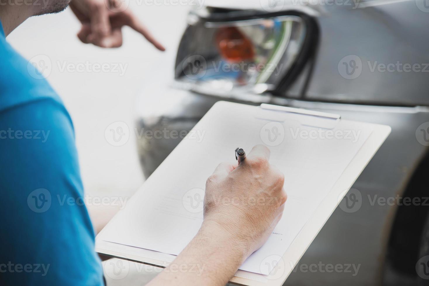 agente de seguros que trabaja durante el proceso de reclamación de accidentes de coche en el lugar - concepto de reclamación de seguros de personas y coches foto