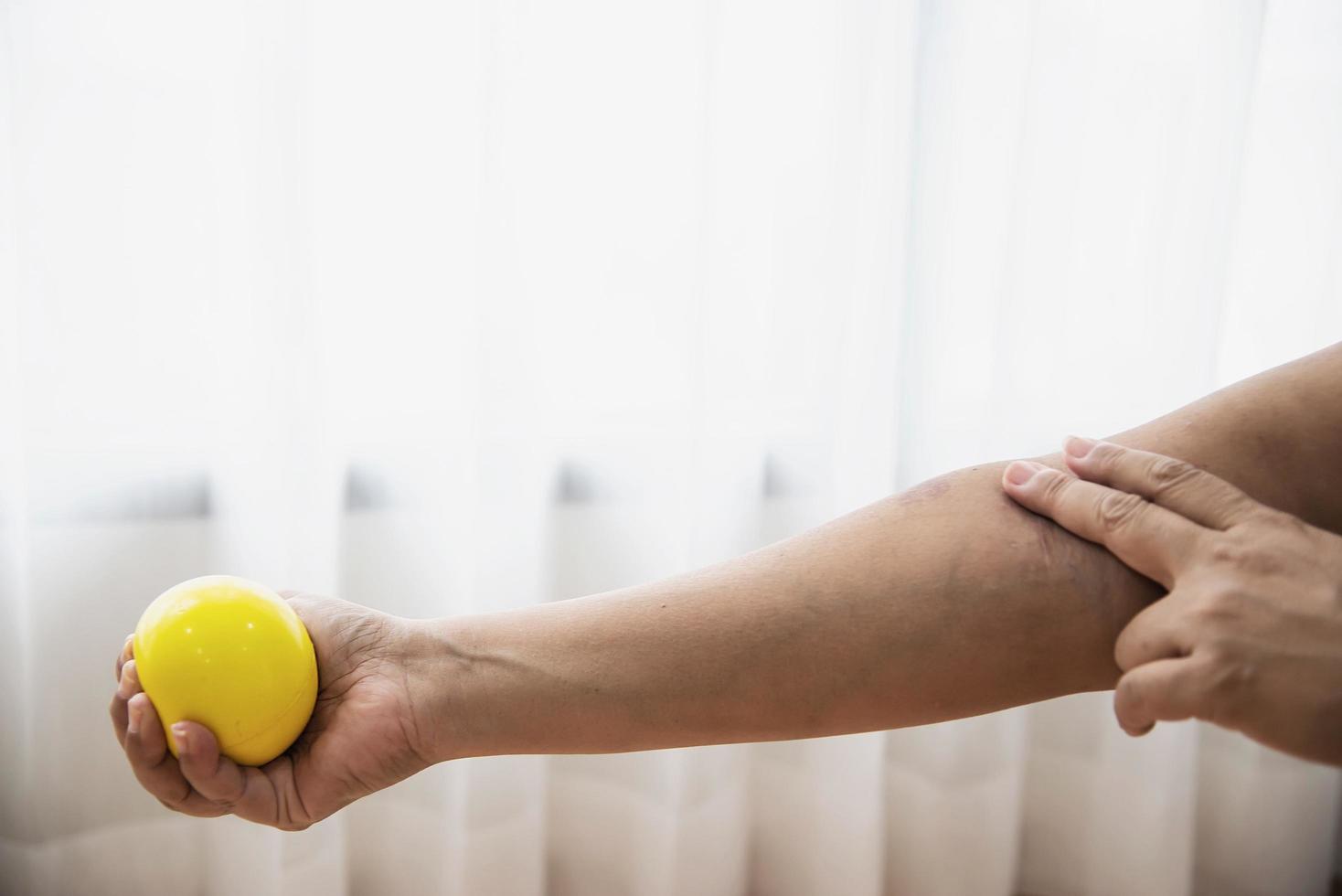 Soft finger and hand exercise ball in patient hand - healthcare medical concept photo