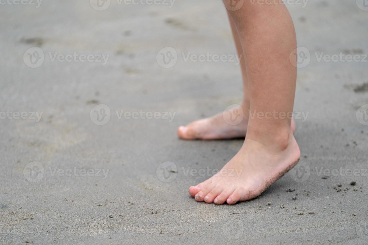 close up kid's legs, play and learn at the beach. photo