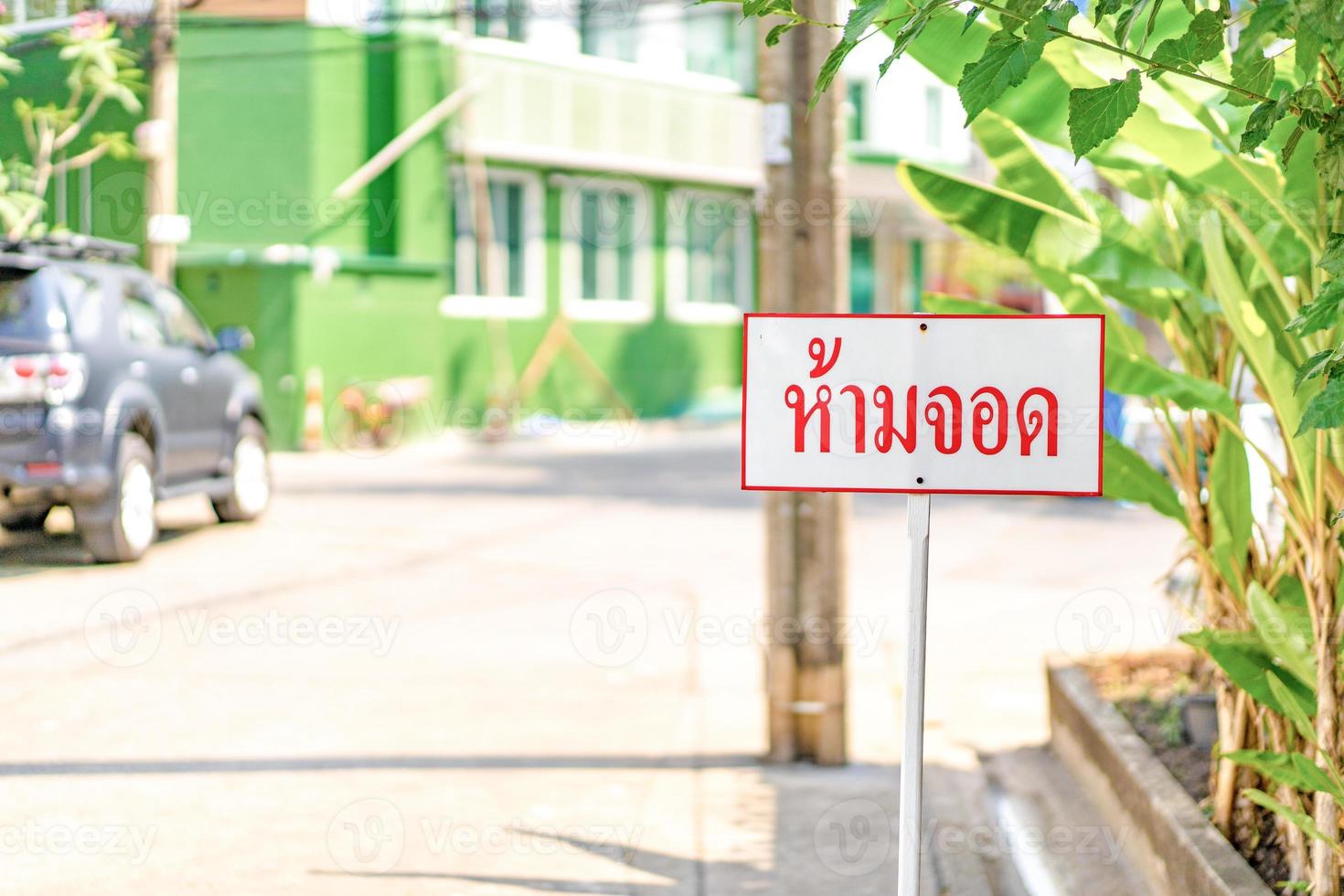 Thailand Sign No Parking standy beside the road in vilage of Bangkok Thailand. The Thai text means No Parking. photo