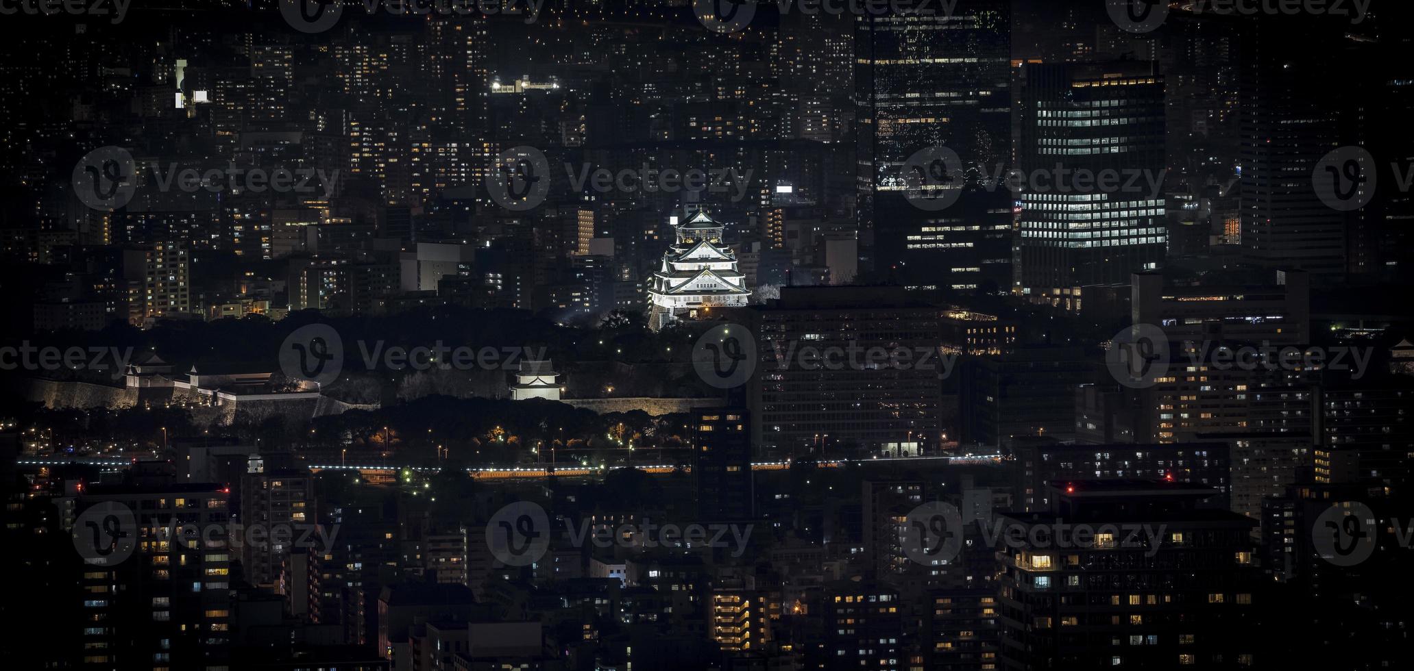 Osaka Castle illuminated at night in panorama  birdeye or top view with cityscape and high building around, Osaka Prefecture, Japan. photo